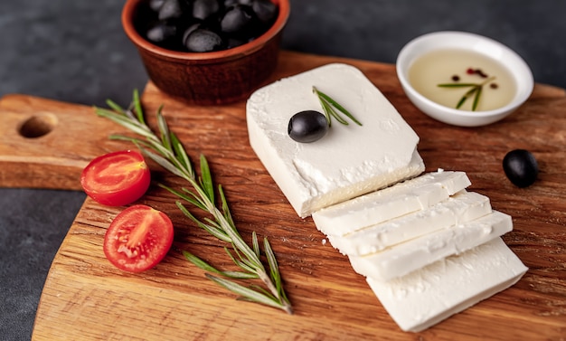 fromage feta, au romarin, tomates, olives sur fond de pierre.