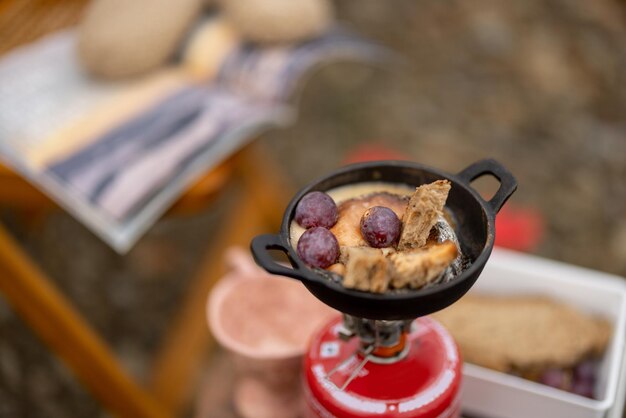 Le fromage fond dans la poêle sur un brûleur à gaz