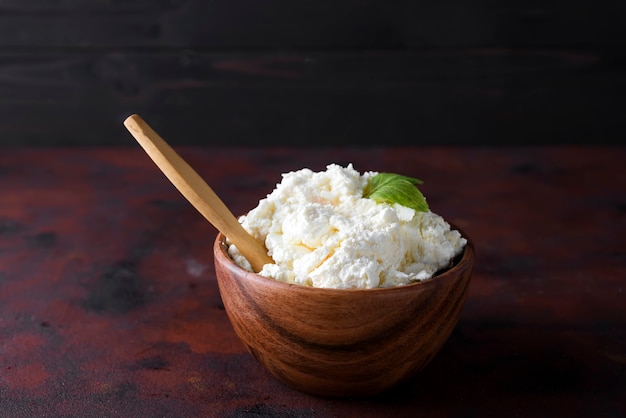 Fromage frais dans un bol en bois et une cuillère