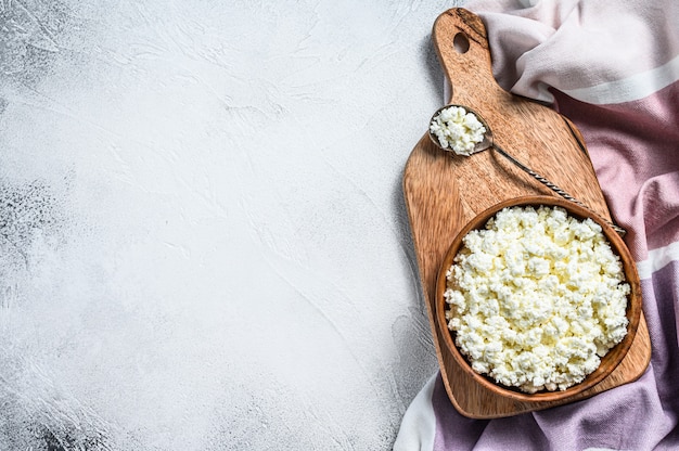 Fromage frais dans un bol en bois. Fond gris. Vue de dessus. Espace copie