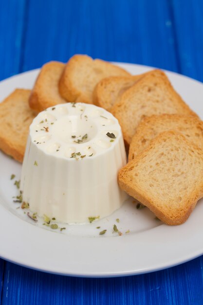 Fromage frais avec des toasts sur plaque blanche