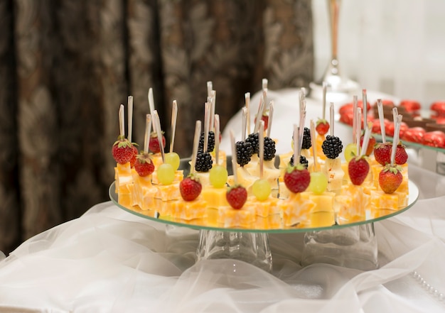 Fromage fraises mûres sur une brochette magnifiquement coupé dans une assiette sur la table