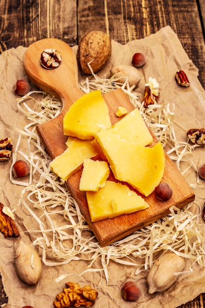 Fromage Gouda vieilli aux noix de pécan noix et noisettes sur la vieille table en bois