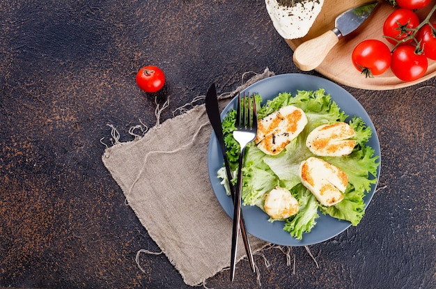 Fromage halloumi grillé avec salade de laitue tomates cerises et fines herbes