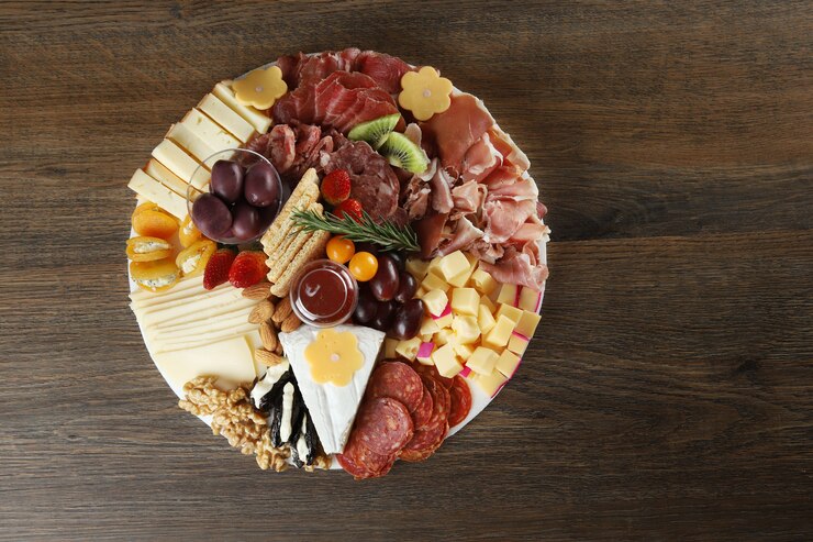 Photo fromage, jambon et saucisse aux olives sur fond de bois