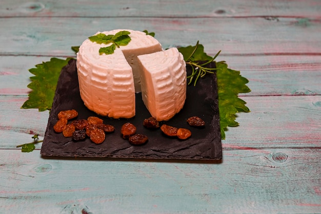 Fromage de lait de chèvre blanc rond fait maison sur planche de bois