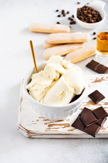 Fromage mascarpone et ingrédients pour faire un tiramisu dessert italien sur un béton léger