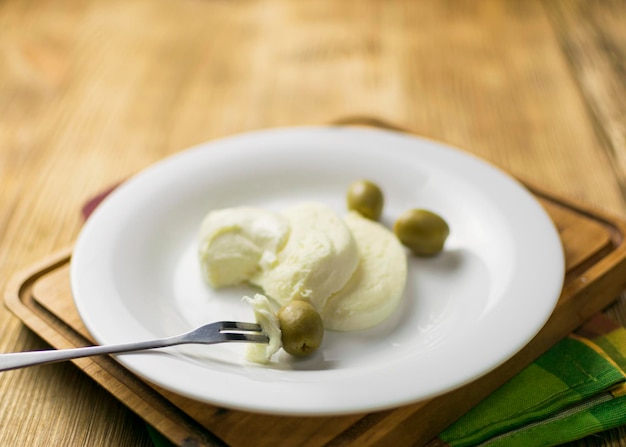 Fromage mozzarella et olives sur une assiette sur un fond en bois