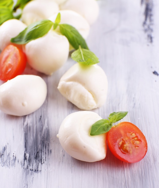 Fromage mozzarella savoureux au basilic et tomates, sur table en bois