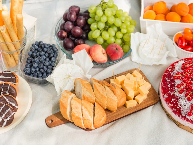 fromage et pain près de fruits sur une couverture