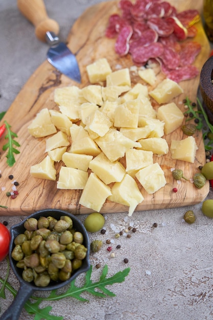 Fromage parmesan haché et légumes sur table grise à la cuisine domestique