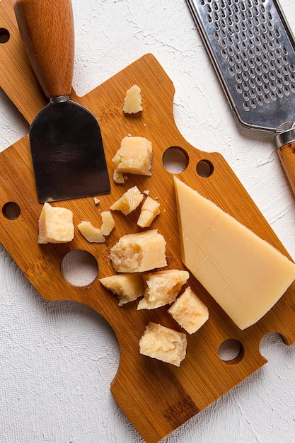 Fromage à pâte dure parmesan sur une planche à découper couteau à fromage râpe vue de dessus aucun peuple