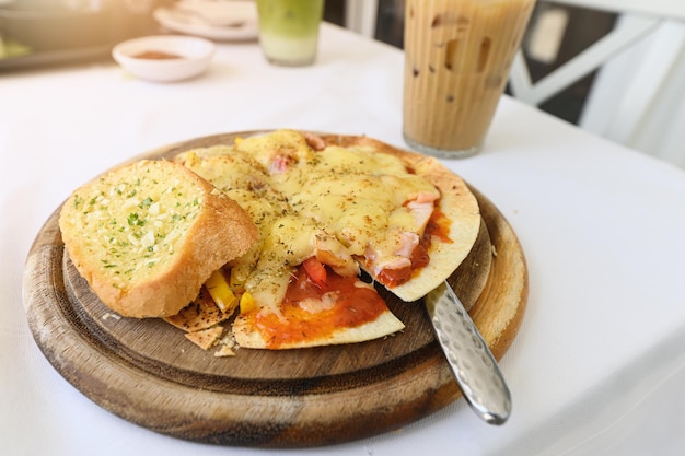 Fromage à pizza croustillant fin avec bacon de jambon de saumon sur plateau en bois