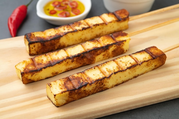 Fromage présure ou Coalho grillé sur une planche de bois avec sirop de sucre et poivre