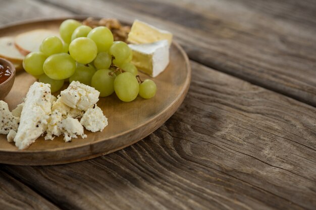 Fromage et raisins sur une plaque en bois