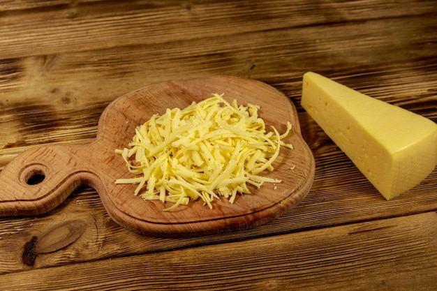 Fromage râpé sur une planche à découper sur une table en bois