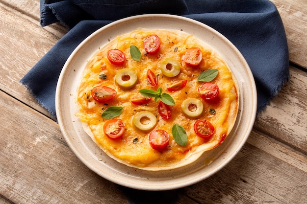 Fromage avec tomates et pâte à pizza au basilic dans une assiette en céramique faite à la main en vue supérieure