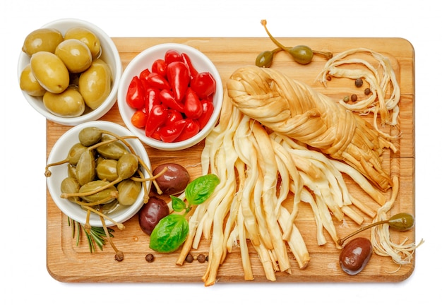 Fromage tressé fumé et légumes sur tableau blanc