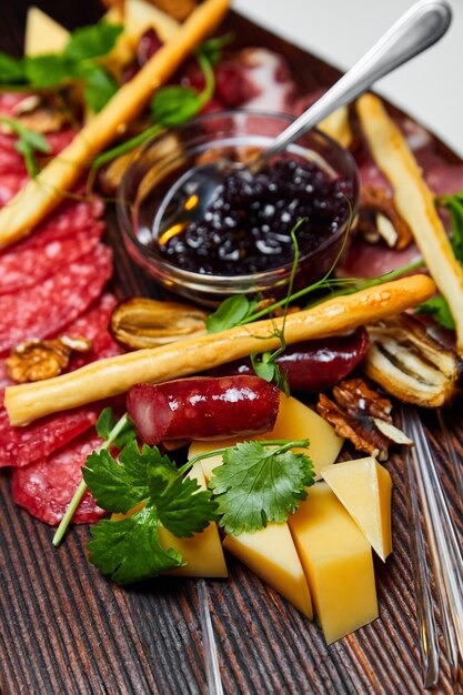 Fromages assortis et spécialités de viande sur planche de bois