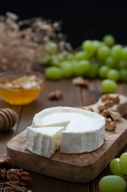 Fromages de chèvre sur bois avec du miel et des raisins