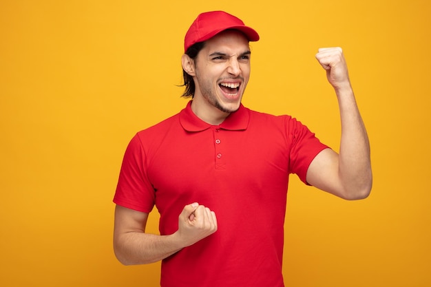 fronçant les sourcils jeune livreur portant l'uniforme et la casquette regardant le côté montrant oui geste isolé sur fond jaune