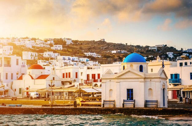 Front de mer coloré avec des églises grecques de Mykonos au coucher du soleil vue de la mer