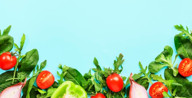 Frontière d'aliments sains avec diverses herbes et légumes verts Ingrédients pour la cuisson de la salade Concept de nourriture végétarienne et végétalienne Vue de dessus cadre bleu avec espace de copie