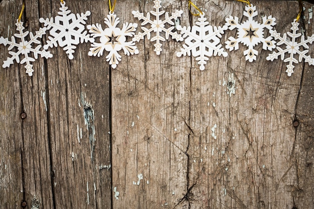 Frontière de flocons de neige sur fond de bois grunge. Concept de vacances d'hiver