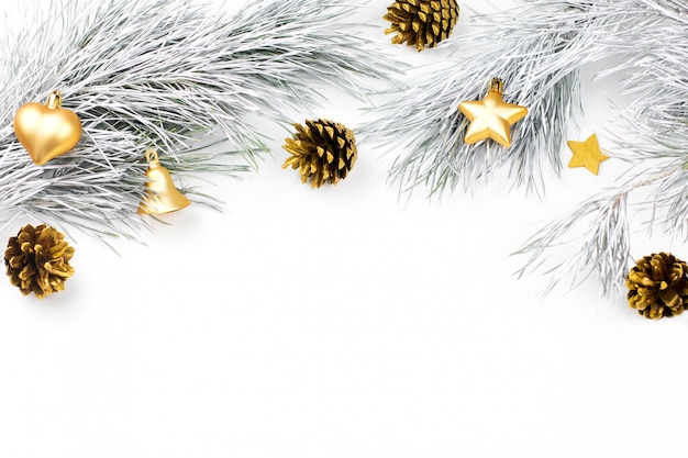 Frontière de Noël avec des branches de sapin, des boules de Noël et des ornements de Noël dorés sur blanc