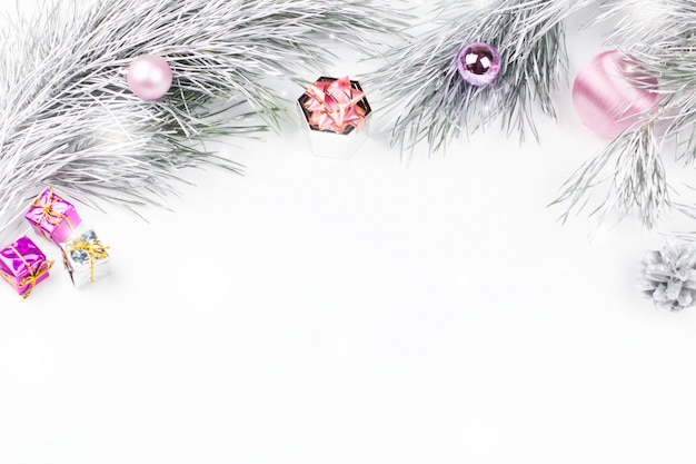 Frontière de Noël avec des branches de sapin, des cadeaux, des décorations de Noël sur blanc