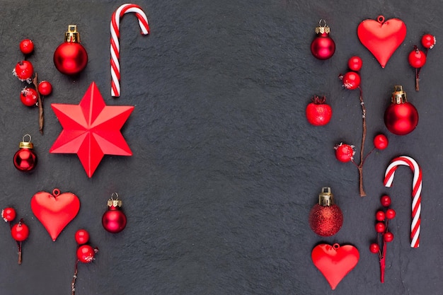 Frontière de Noël sur fond noir Composition de Noël rouge avec un décor de Nouvel An rouge Vue de dessus à plat sur fond sombre avec espace de copie