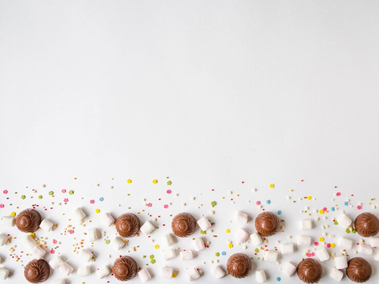 Frontière de pâtisserie festive sucrée avec du chocolat, des guimauves et une garniture de pâtisserie sur fond blanc