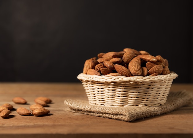 Fruit amande snack dans un panier blanc sur bois