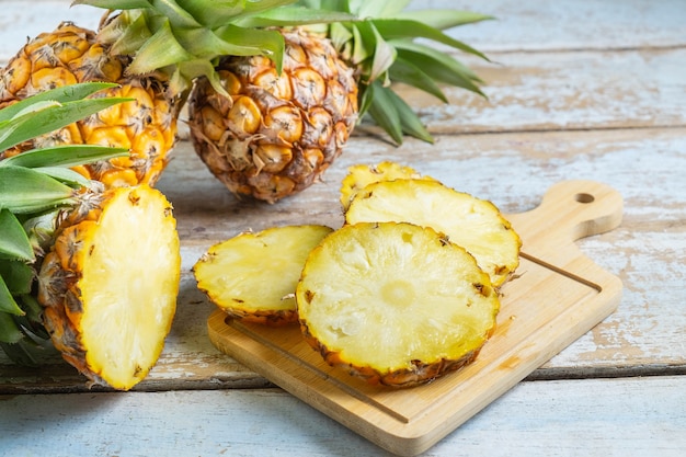 Fruit d&#39;ananas frais tranché sur une planche à découper en bois