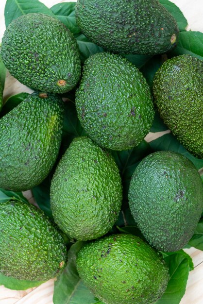 Fruit d'avocat avec des feuilles sur le fond en bois