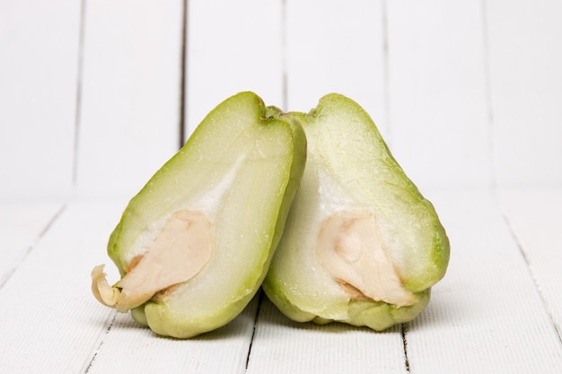 Fruit de la chayote sur fond de bois blanc