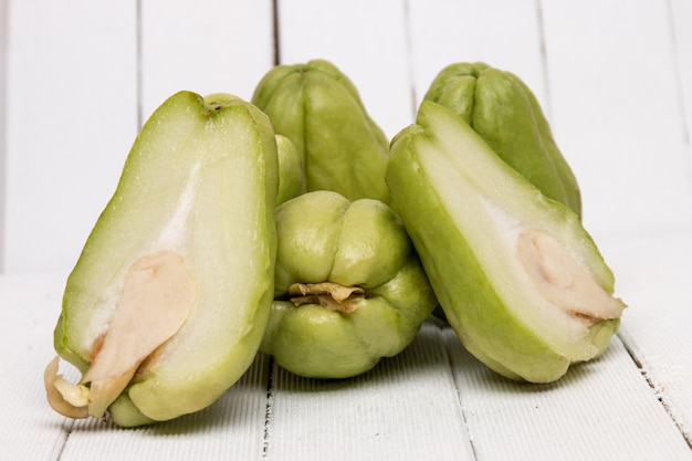 Fruit de la chayote sur fond de bois blanc