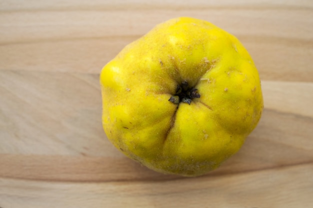 fruit de coing sur un plateau en bois