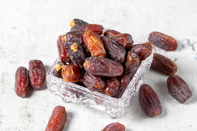 Fruit de datte sur fond de pierre Dattes de Medjoul organiques dans un bol de verre Nourriture du Ramadan en gros plan