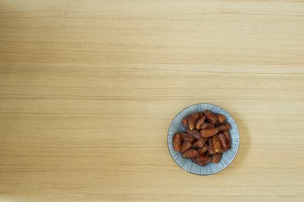 Fruit de dattes douces et séchées dans un bol et sur la table