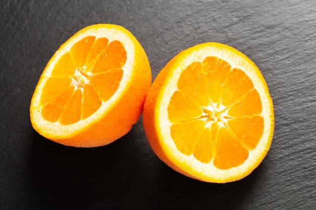 Fruit du concept alimentaire bio fruits orange ou pomelo coupés sur ardoise noire