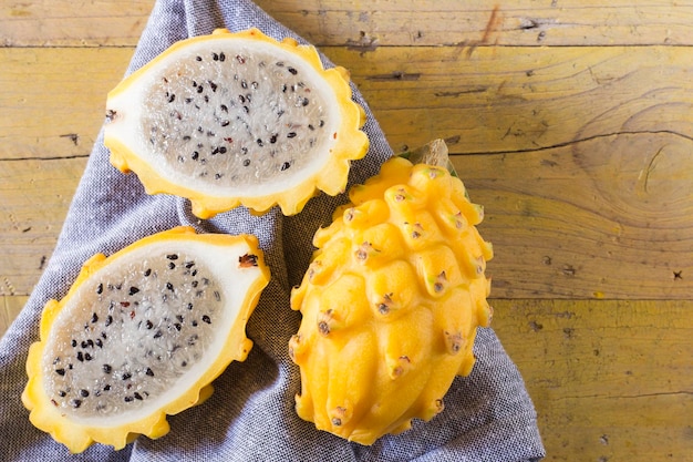 Fruit du dragon pitahaya jaune sur fond de bois