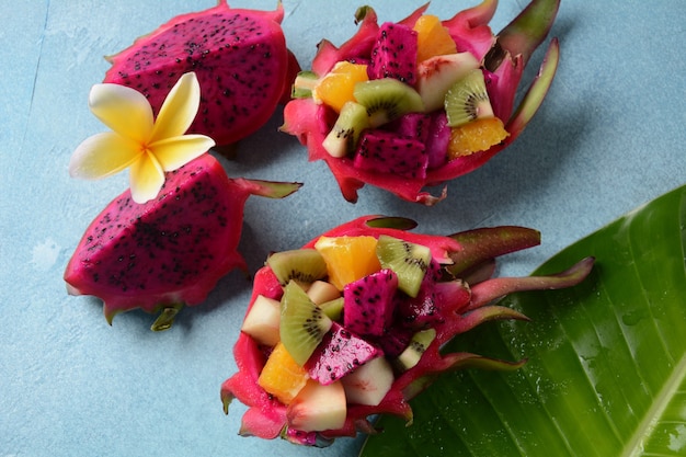 Fruit du dragon (Pitaya, Pitahaya). Morceaux tranchés de fruits pitahaya et salade de fruits, et fleurs de frangipanier.