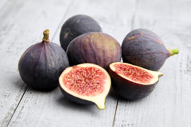 Fruit de figue avec des moitiés mûres rouges sur une table en bois