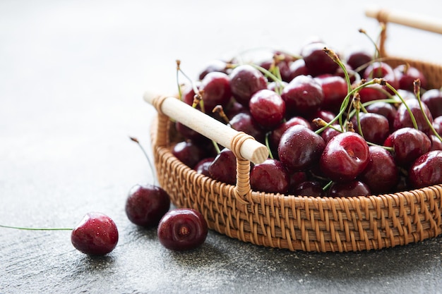 Fruit frais de cerises rouges sur le plateau en osier