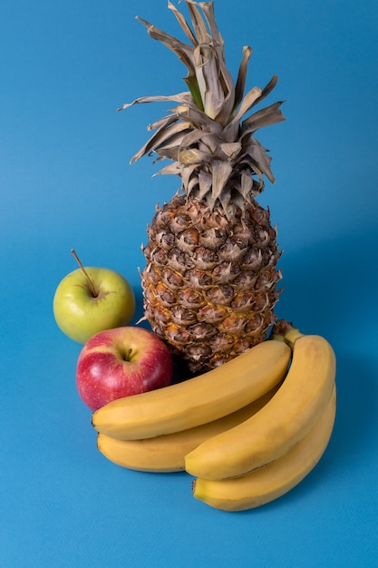 Fruit - Fruit d&#39;ananas, pomme et banane sur fond bleu.