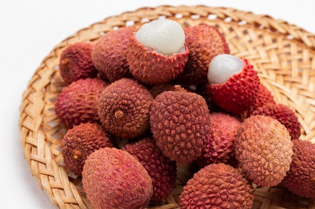 Fruit de litchi sur plaque en osier Close up Vue de dessus Fond blanc