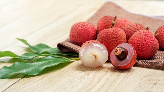 Fruit de litchi rouge sur une table en bois.