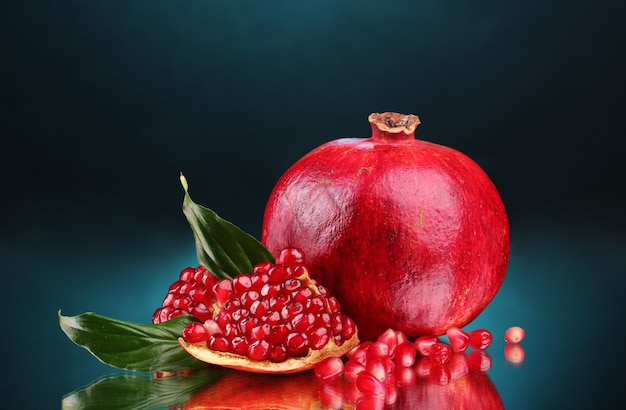 Fruit mûr de grenade avec des feuilles sur le bleu