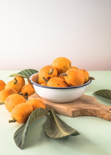 Fruit de néflier mûr Eriobotrya japonica et feuilles de néflier vert sur table en bois Vue de dessus